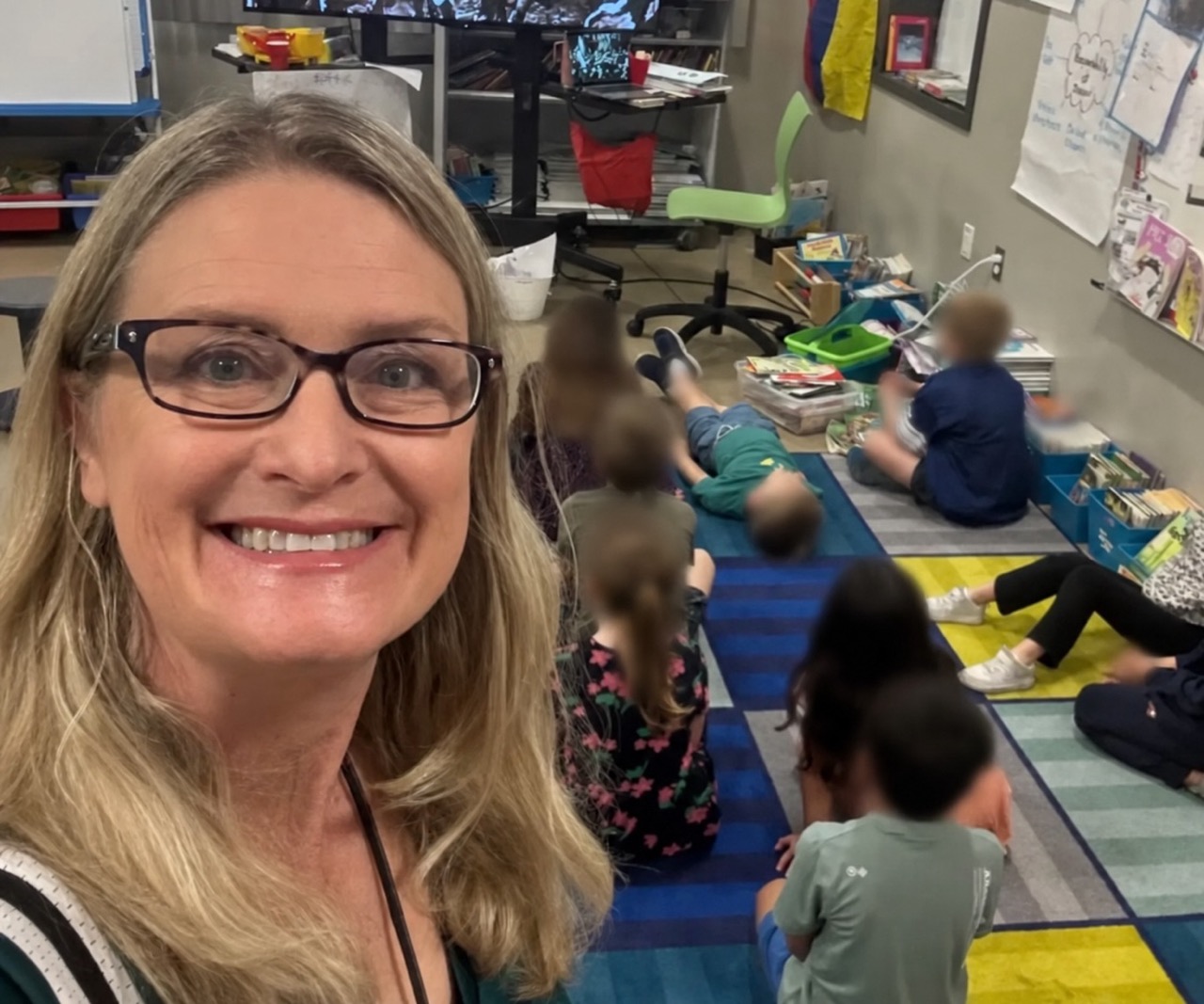 Retired elementary teacher Amy in her classroom with student faces blurred for privacy